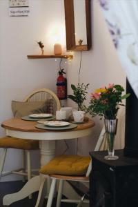 a small table with chairs and a table with flowers on it at Little Woodacott in Barnstaple +14 photos