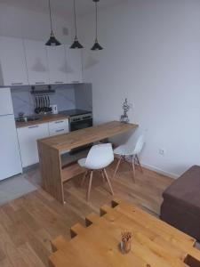 a kitchen with a wooden table in a room at Apartman Symbol in Tuzla