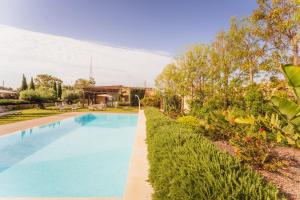 a swimming pool in a garden with a mountain in the background at New to the market - 4BR Farmhouse with Pool by SF Homes in Siġġiewi