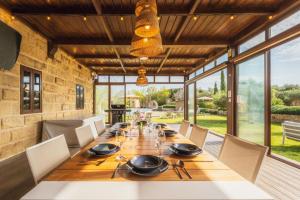 a dining room with a long wooden table and chairs at New to the market - 4BR Farmhouse with Pool by SF Homes in Siġġiewi