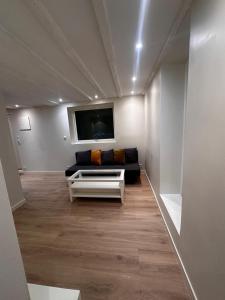 a living room with a couch and a flat screen tv at Abildsø Apartment in Oslo