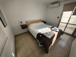 ein Schlafzimmer mit einem Bett, auf dem ein Handtuch liegt in der Unterkunft Aloha 3 in Chacabuco