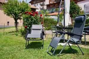 two chairs and an umbrella on the grass at Attic House Mountain Lake Iseo Hospitality in Bossico