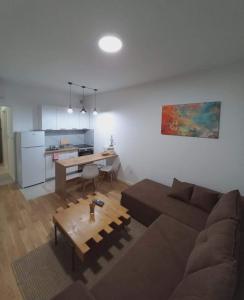 a living room with a couch and a table at Apartman Symbol in Tuzla