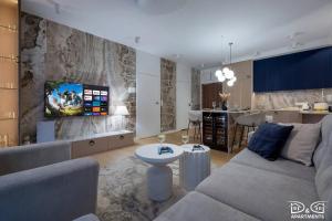 a living room with a couch and a tv on a wall at Apartament POGO LOVERS in Pogorzelica