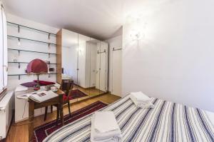 ヴェネツィアにあるBiennale suiteのベッド、テーブル、デスクが備わる客室です。