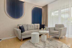 a living room with a couch and two chairs and a table at Apartament POGO LOVERS in Pogorzelica
