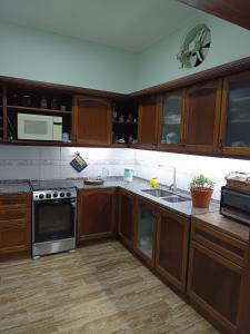 a kitchen with wooden cabinets and a stove top oven at Refugio Quilmes Centro - Work & Relax in Quilmes