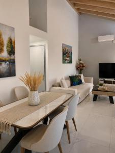 a living room with a table and a couch at Villa Harmonia II-Seafront Retreat in Livadáki