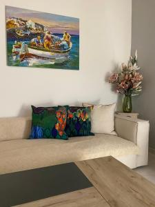 a couch in a living room with a painting on the wall at Villa Harmonia II-Seafront Retreat in Livadáki