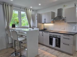a kitchen with white cabinets and a counter with a table at Reload Apartments - FeWo1 im Remmeker Feld in Bad Arolsen