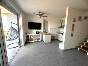 a living room with a flat screen tv and a kitchen at Anai Jadranovo Sea View Penthouse in Jadranovo +13 photos