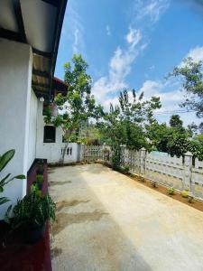 a house with a white fence and a driveway at Chill Bill Holiday inn in Haputale