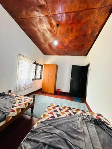 a room with two beds and a wooden ceiling at Chill Bill Holiday inn in Haputale