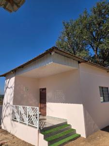 a small white building with stairs in front of it at Rainbow Cottage Stays in Kānha