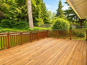 a wooden deck with a fence and a tree at Bellevue Pet friendly Home Fenced Yard in Bellevue