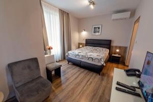 a bedroom with a bed and a chair and a desk at Opera Family Hotel - former City Mark hotel in Varna City