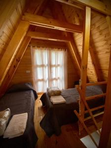 an attic room with two beds and a window at Cabañas Damel in Villa Giardino +31 photos