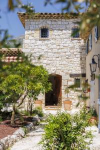 a stone building with a wooden door in a yard at villa la Sine in Vence