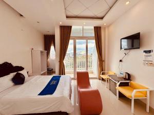 a hotel room with a bed and a desk and a tv at Nice Hotel Buôn Ma Thuột in Buon Ma Thuot +137 photos