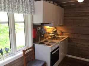a kitchen with a stove and a sink and two windows at Senja, Villa View in Senja