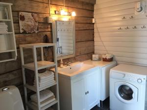 a bathroom with a sink and a washing machine at Senja, Villa View in Senja