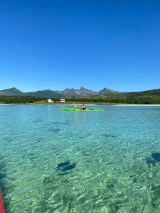 a person in a kayak in the water at Senja, Villa View in Senja