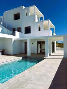 a white house with a swimming pool in front of it at DIA suites collection in Mikri Vigla