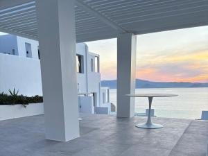 a patio with a table and a view of the ocean at DIA suites collection in Mikri Vigla