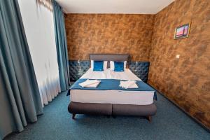 a bedroom with a bed with blue pillows at Opera Family Hotel - former City Mark hotel in Varna City