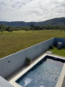 a swimming pool on the side of a house with a field at Escobar Sunset in Paraguarí