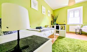 a green room with a bed and a lamp in it at Geräumiges & helles Apartment nahe Leipzig in Böhlen