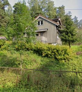 a house sitting on top of a hill with trees at Abildsø Apartment in Oslo