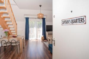 a living room with a table and chairs and a staircase at Captain's Quarters - with Terrace and Parking near Lake Balaton in Keszthely