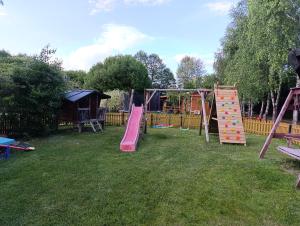 a playground with a bunch of play equipment in the grass at Agrodomek in Łowyń