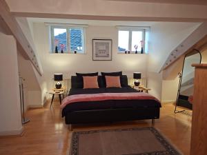 a bedroom with a bed and two windows at Rosarote Insel - La Vie en Rose in Lindau