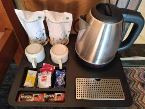 a tray with a tea kettle and some snacks at Rainbow Cottage Stays in Kānha
