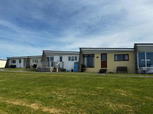 a row of houses with a lawn in front of them at Bungalow 19 Widemouth Bay in Poundstock