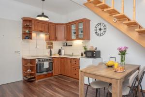 a kitchen with wooden cabinets and a wooden table at Captain's Quarters - with Terrace and Parking near Lake Balaton in Keszthely