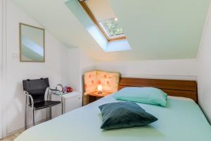 a bedroom with a bed and a window and a chair at Guesthouse Sobe Silva in Tolmin