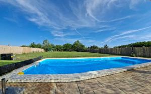 a swimming pool in a yard with a fence at Villa Sunset in Palić