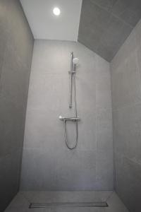 a shower in a bathroom with a tiled wall at Reload Apartments - FeWo2 im Remmeker Feld in Bad Arolsen +19 photos