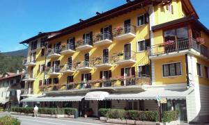 un edificio amarillo con balcones en una calle en Hotel Posta, en Comano Terme