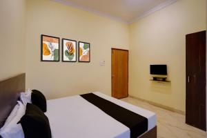a bedroom with a bed and a television at Hotel O Maa JP Tower in Jabalpur