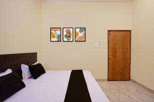 a bedroom with a bed and a wooden door at Hotel O Maa JP Tower in Jabalpur +23 photos