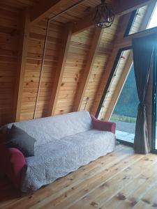 eine Couch in einem Zimmer mit einem großen Fenster in der Unterkunft Mariiko's cottages in Iprari