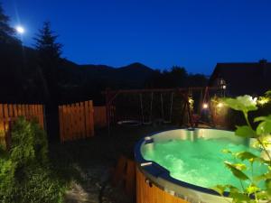 a hot tub in the yard at night at Dzika Stokrotka in Idzików