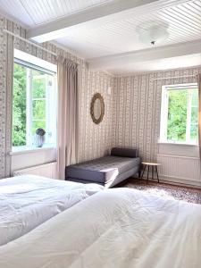 a bedroom with two beds and two windows at Kronovall Park Residence in Skåne-Tranås