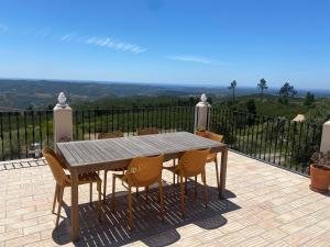 a wooden table and chairs on a patio with a view at Quinta O Ninho in Monchique
