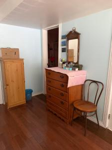 a bathroom with a sink and a mirror and a chair at Cozy EnSuite No Pets Allowed in Burnaby +2 photos